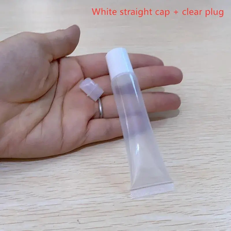 Empty clear lipstick tube with white cap; translucent plastic squeeze bottle, 2 pieces shown