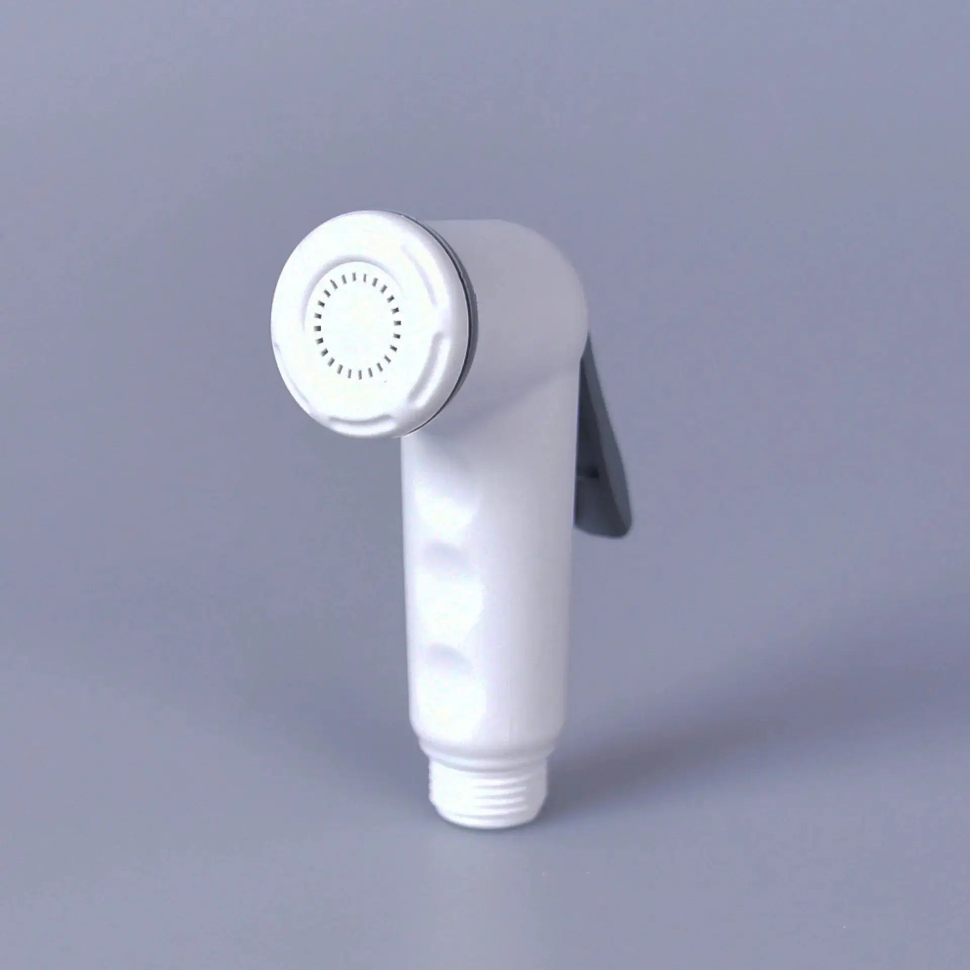 Handheld toilet bidet nozzle with white ABS body and round spray head on gray background