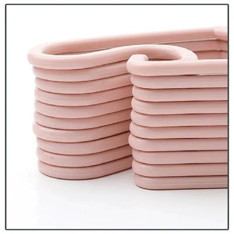 Baby clothes hangers, pink plastic, stacked neatly in a bundle
