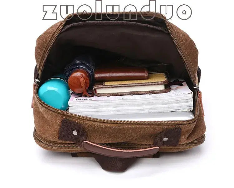 Brown vintage canvas backpack for men with large capacity, opened to reveal notebooks, water bottle and wallet inside.