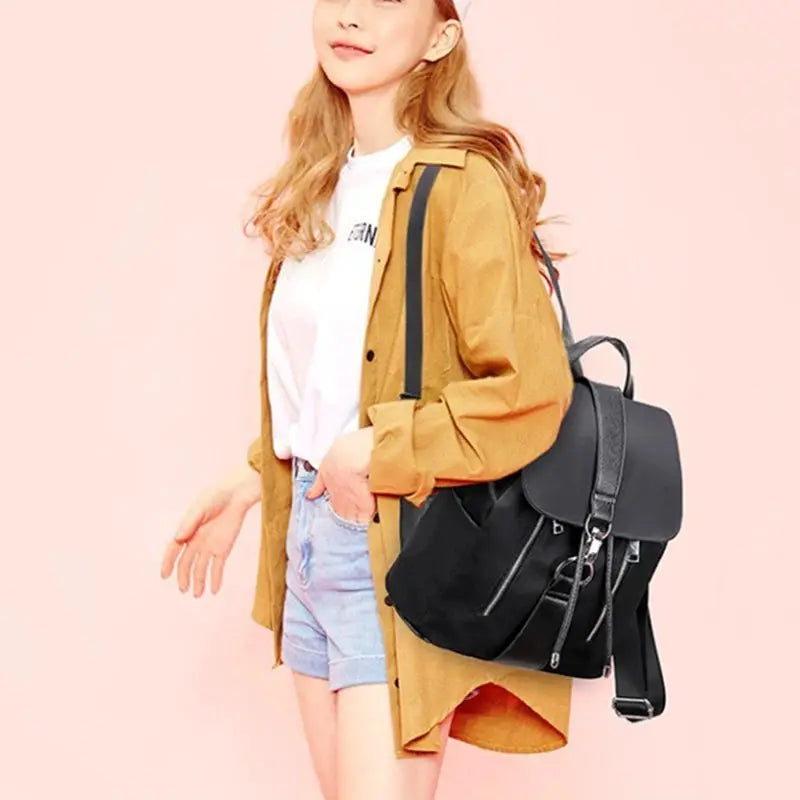 Women's nylon backpack by Simples Market, black with flap top and front zipper pockets, large capacity.
