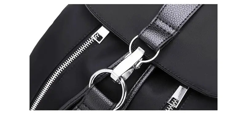 Women's backpack in black nylon with silver hardware and zippers.