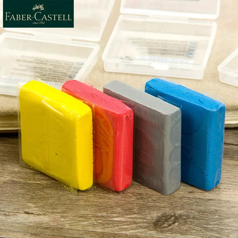 Faber-Castell Plasticity erasers set of 4 in yellow, pink, gray and blue on a wooden desk