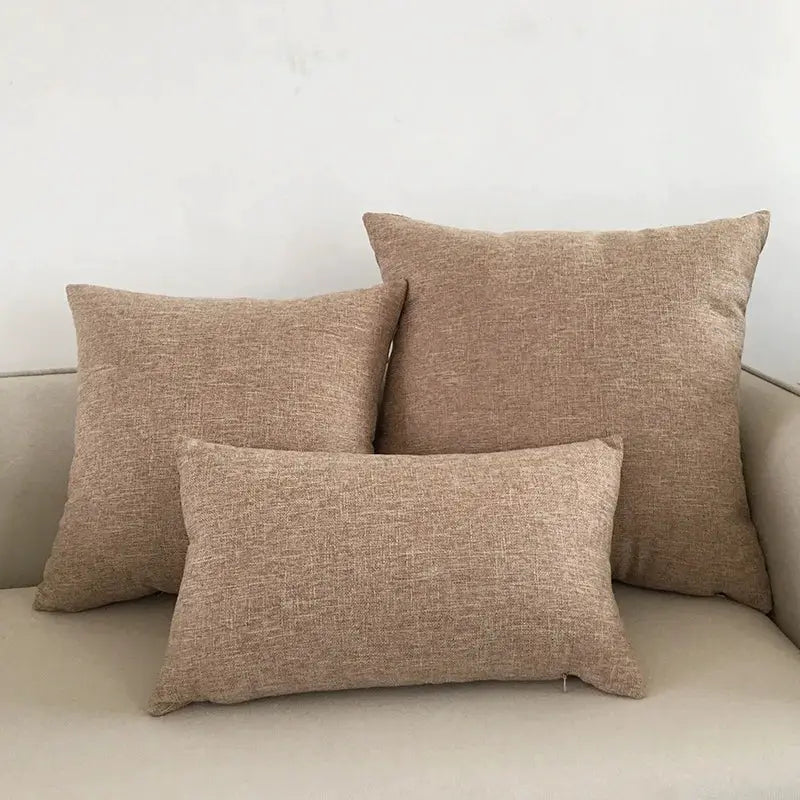Beige textured sofa cushion covers, set of three decorative throw pillow cases in assorted sizes.