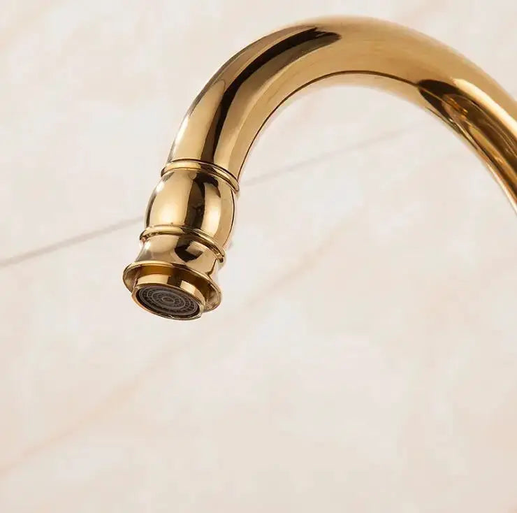 Golden brass kitchen faucet with curved swivel spout and single-handle design
