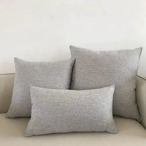 Sofa cushion covers in light gray woven fabric; decorative throw pillow cases, shown with three cushions.