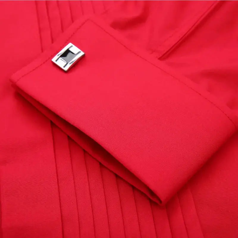 Men's red dress shirt cuff with silver cufflink and pleated front