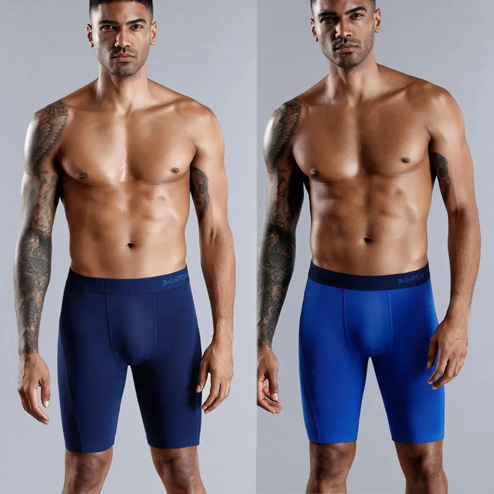 Two pairs of Simples Market long-leg cotton boxer shorts in navy and royal blue.