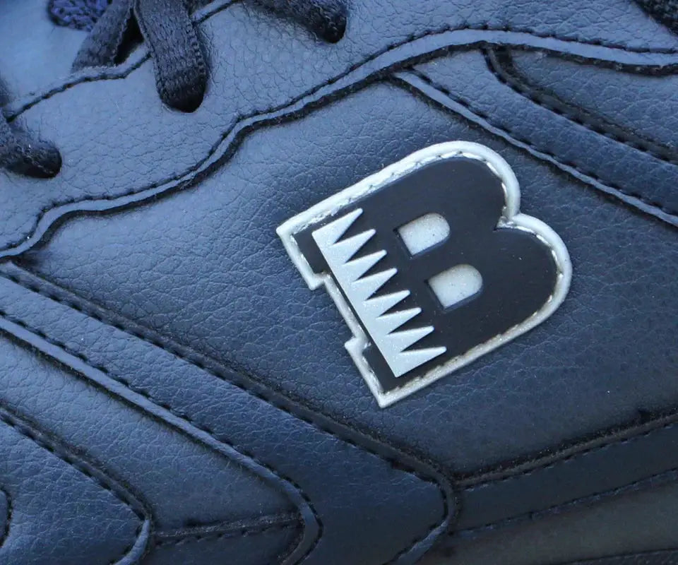 Men's black leather running shoe with lace-up design and a white-stitch stylized B logo patch