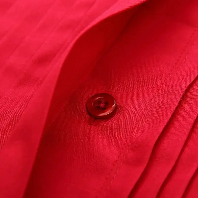 Red dress shirt close-up with a red button on the placket.