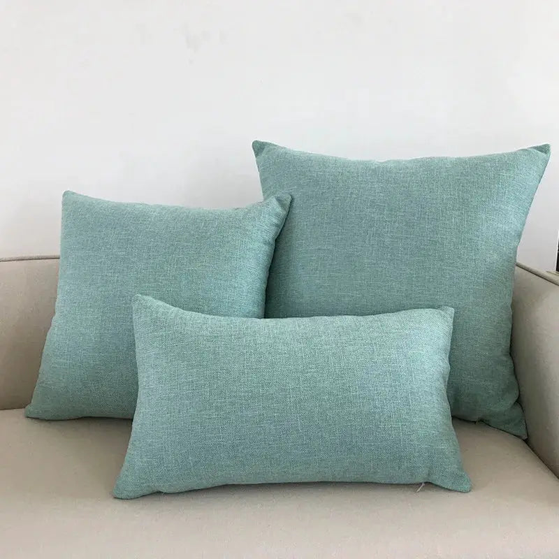 Sofa cushion covers in teal linen texture, set of three decorative throw pillows on beige sofa.