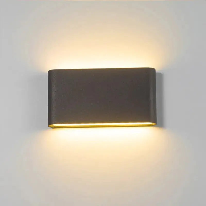 LED wall lamp in dark gray aluminum, emitting warm light upward and downward.
