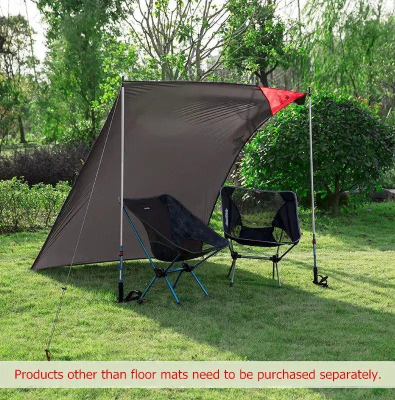 Camping canopy shelter in brown with a red accent, set up with two folding chairs on a grassy park lawn