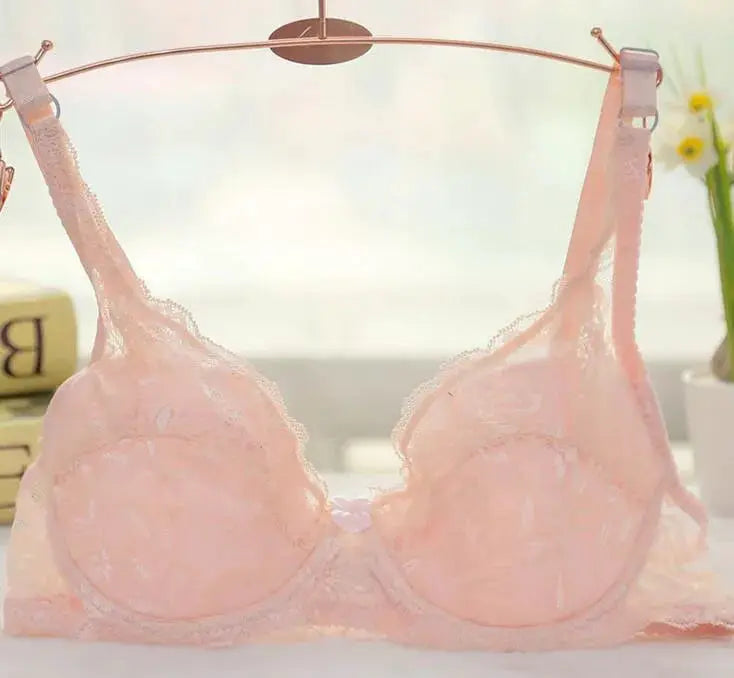 Pink lace underwire push-up bra on a hanger, pale peach shade with scalloped lace
