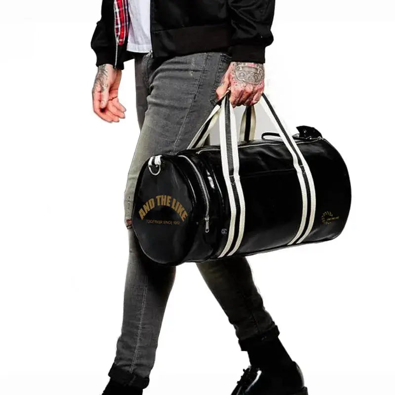 Sport gym bag in black leather-style with white straps, carried by a person; includes shoe storage pocket.