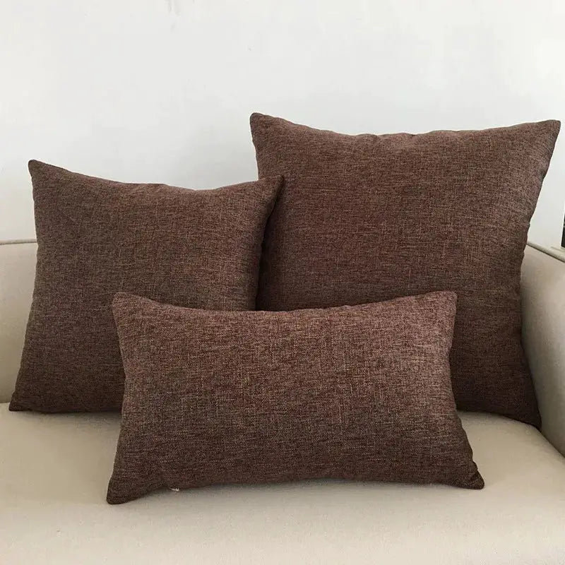 Sofa cushion covers in brown textured fabric; set of three on a beige sofa.