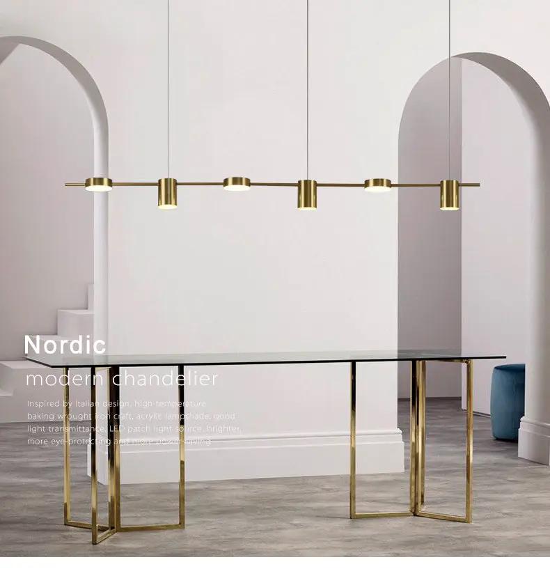 Modern LED linear chandelier, brass finish, dimmable, over a glass dining table.