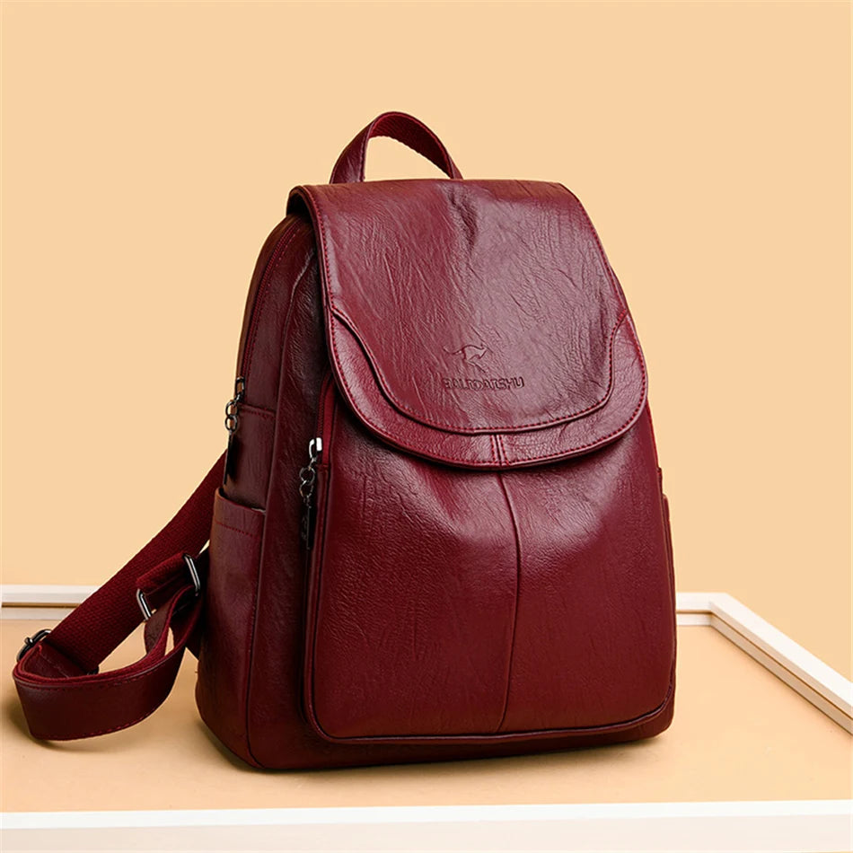 Genuine leather backpack for women in burgundy with front flap, top handle and adjustable straps