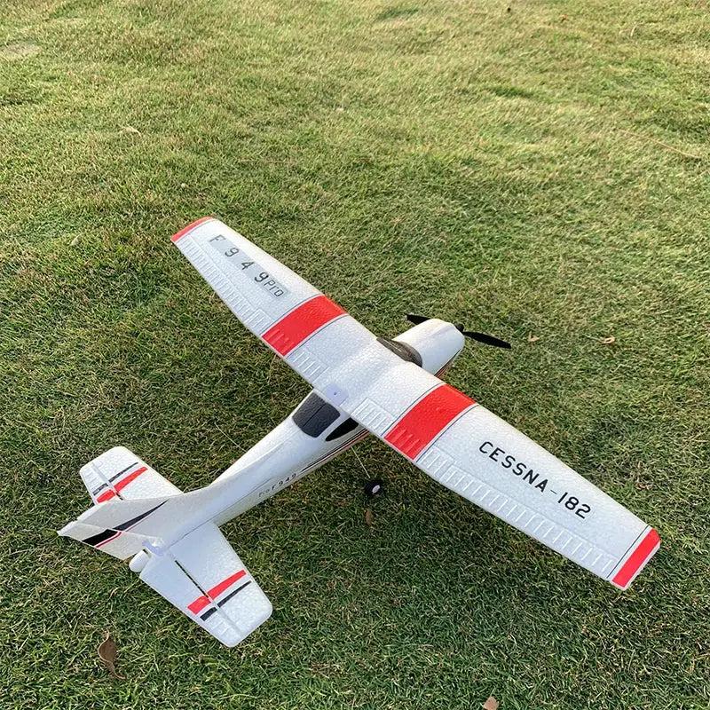 WLtoys F949 Cessna 182 RC airplane on grass, white with red bands, fixed-wing 3-channel with gyro