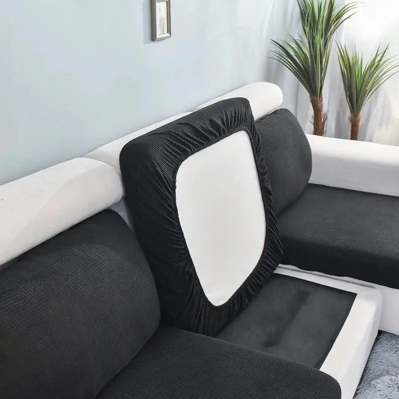 Sofa seat cushion cover in black stretch fabric with white center panel; removable, washable slipcover.