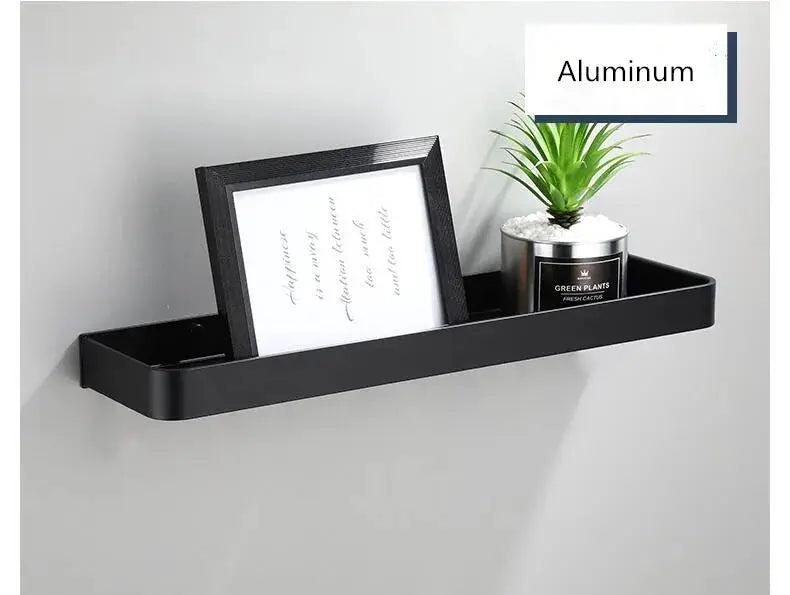 Wall-mounted black aluminum bathroom shelf with a framed photo and a small plant