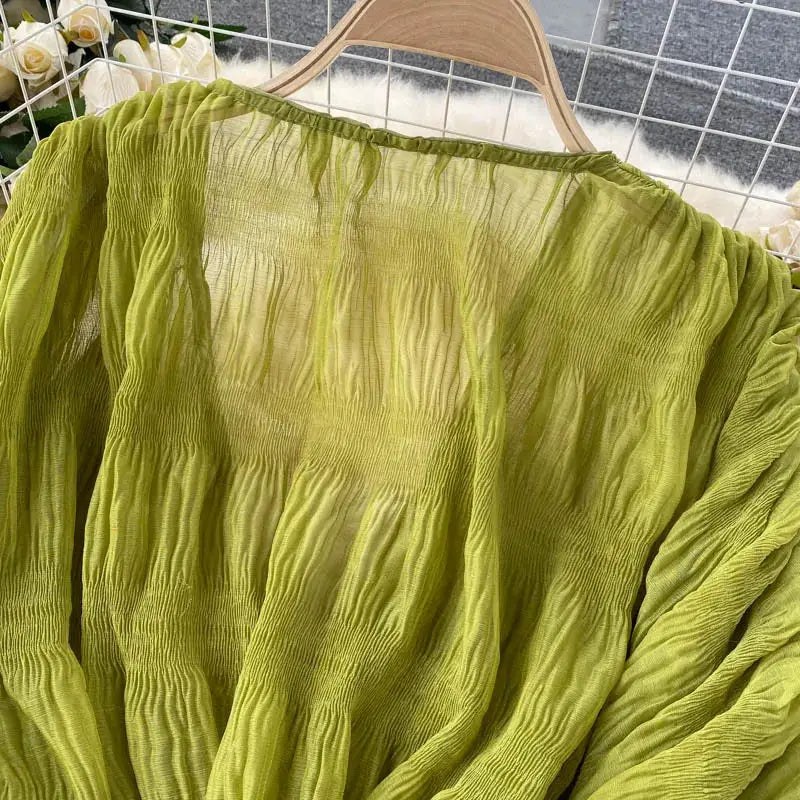 Lime green chiffon blouse on hanger with ruched textured panels and long puff sleeves