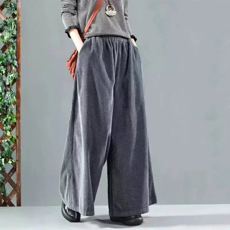 Women's gray wide-leg corduroy pants with striped mid-sleeve top and brown crossbody bag, casual vacation outfit.