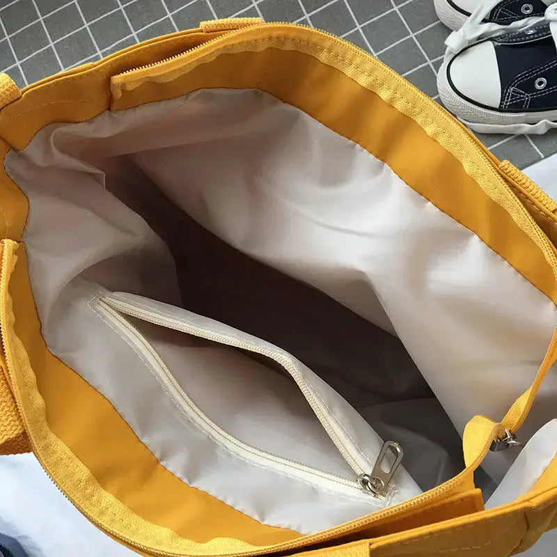 Waterproof Oxford large-capacity women's handbag by Simples Market; yellow exterior with interior zip pocket.
