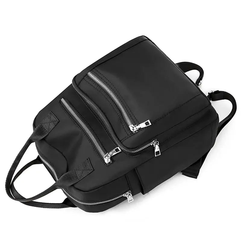 Women's black backpack with multiple zip pockets, adjustable shoulder straps, large capacity.