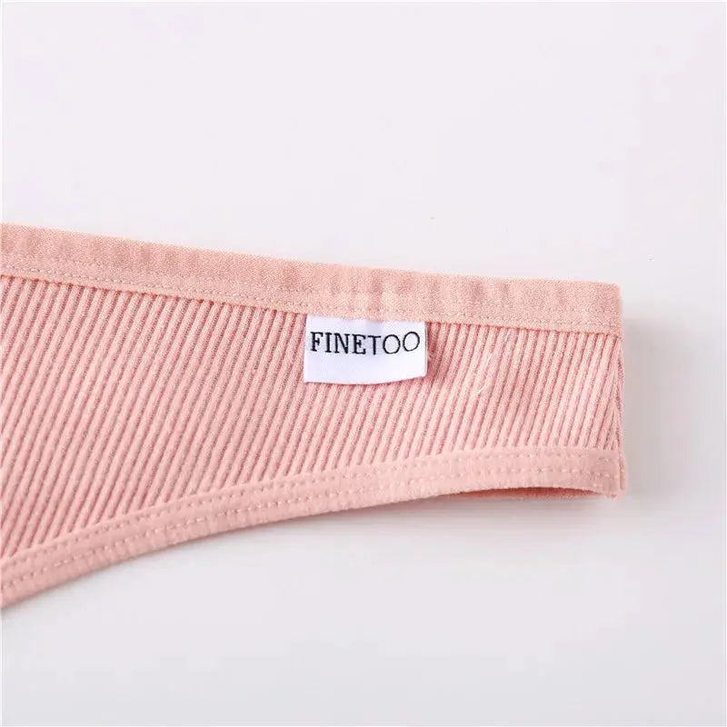 Thong in pink ribbed cotton with FINETOO label, close-up waistband detail.