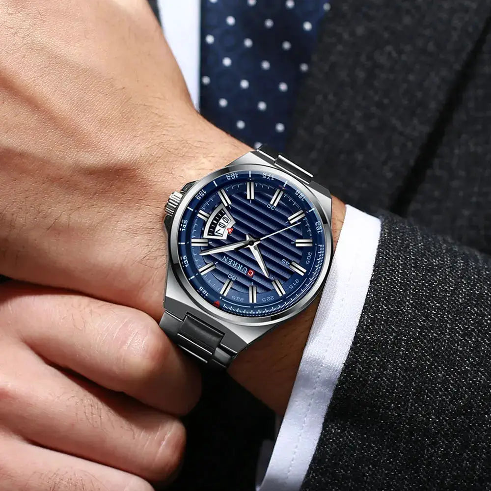 CURREN men's luxury watch with blue striped dial and stainless steel bracelet worn on the wrist, with bold markers