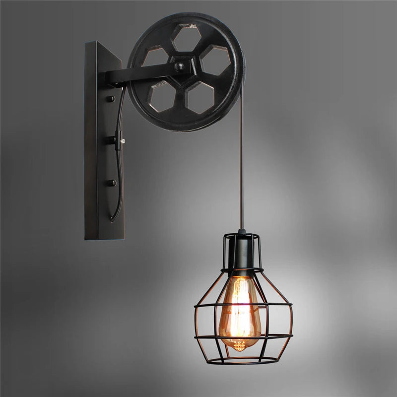 Vintage industrial wall sconce in black metal with pulley and cage lamp, with exposed Edison bulb.
