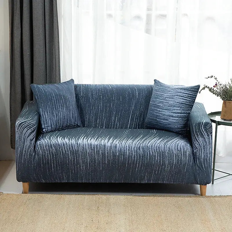 Sofa slipcover in blue printed stretch fabric on a living room sofa with matching cushions