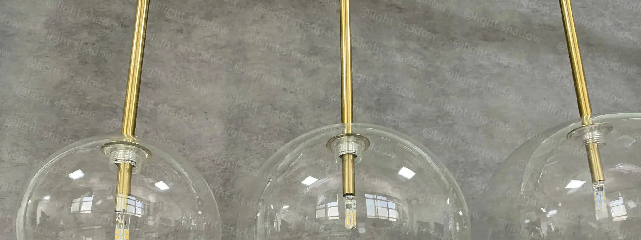 Modern LED pendant lamp with three clear glass globes on brass suspensions by Simples Market