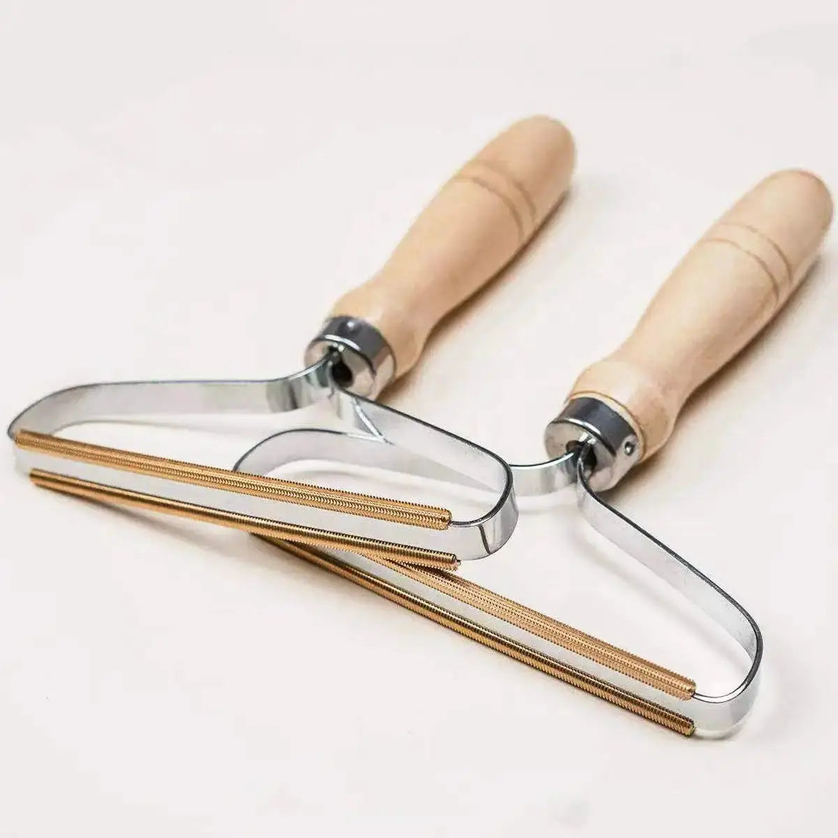 Portable lint remover tool with wooden handles and clear curved guard housing gold rollers