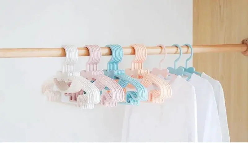 Baby clothes hangers set; pastel plastic colors on a wooden rod for kids' shirts and coats
