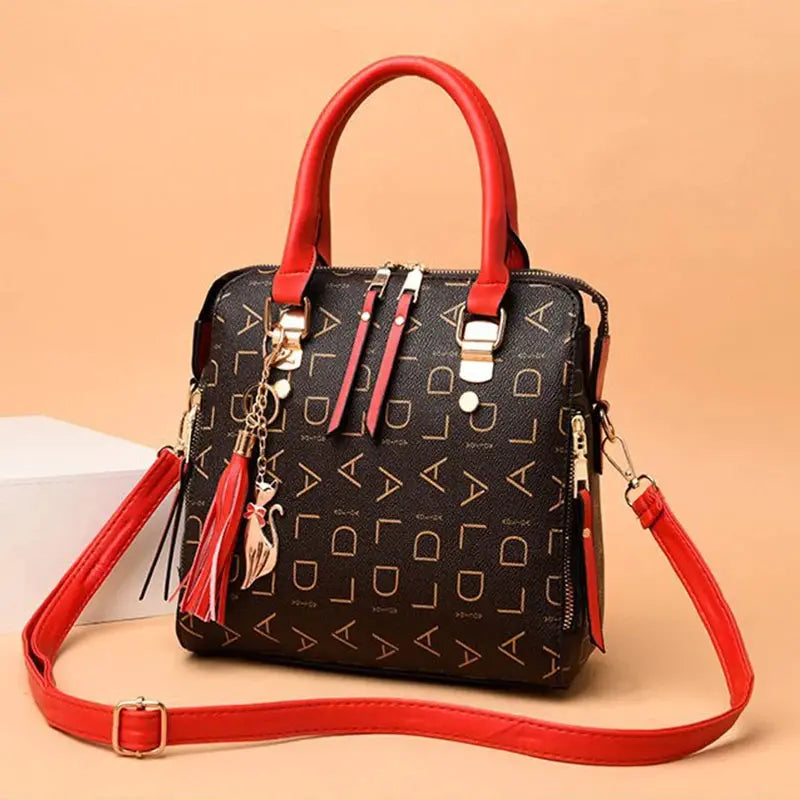 Women’s PU leather handbag with red top-handle and crossbody strap, black bag with English letter print and tassel charm