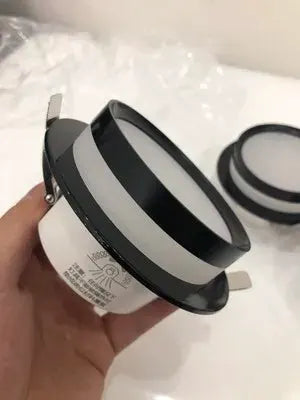 Round recessed LED downlight with white housing and black trim