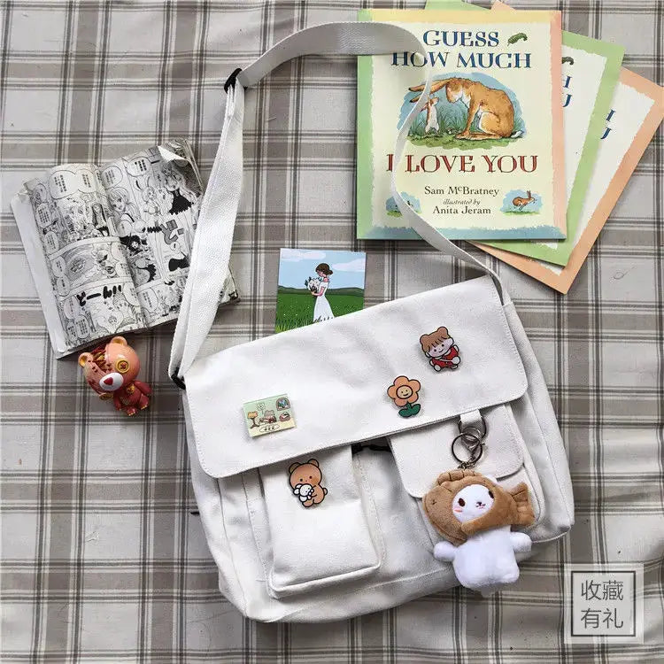 Women's canvas messenger bag by Simples Market with cartoon patches and plush charm, white/cream