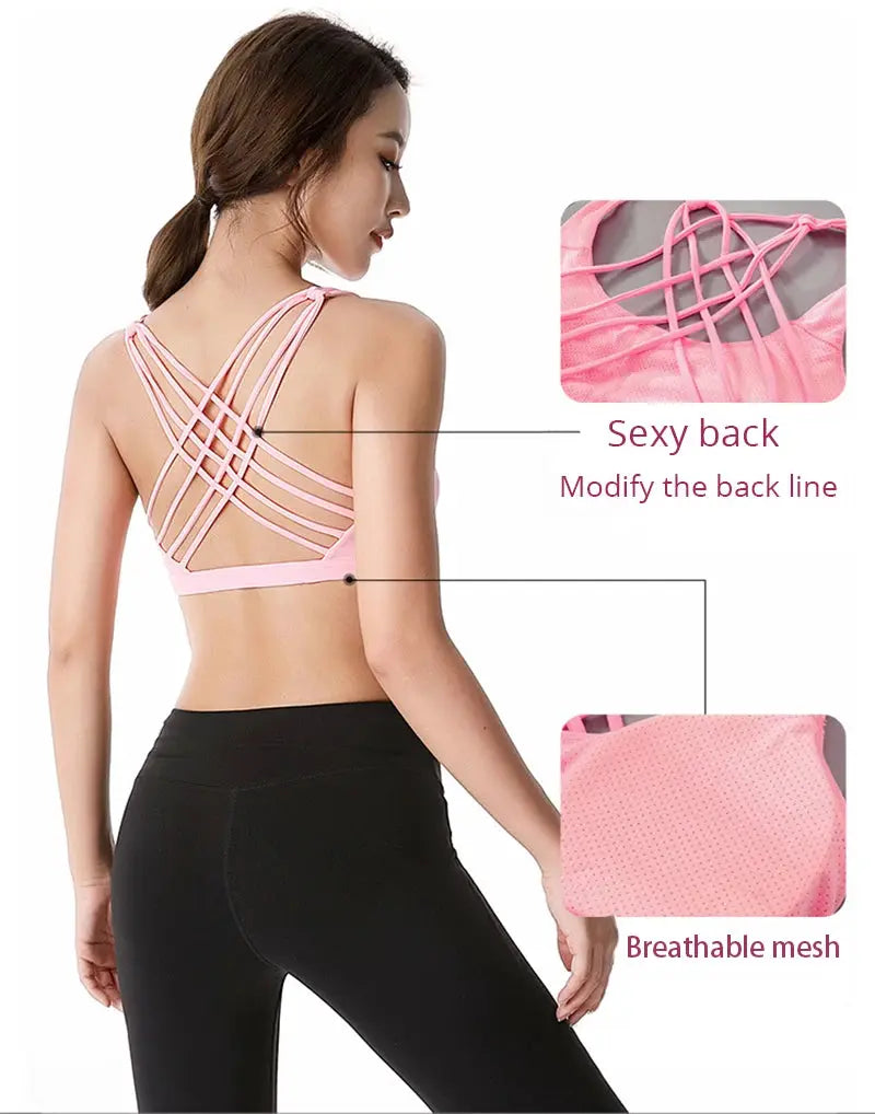 Pink women's cross-back strappy sports bra with breathable mesh for gym, running, and yoga