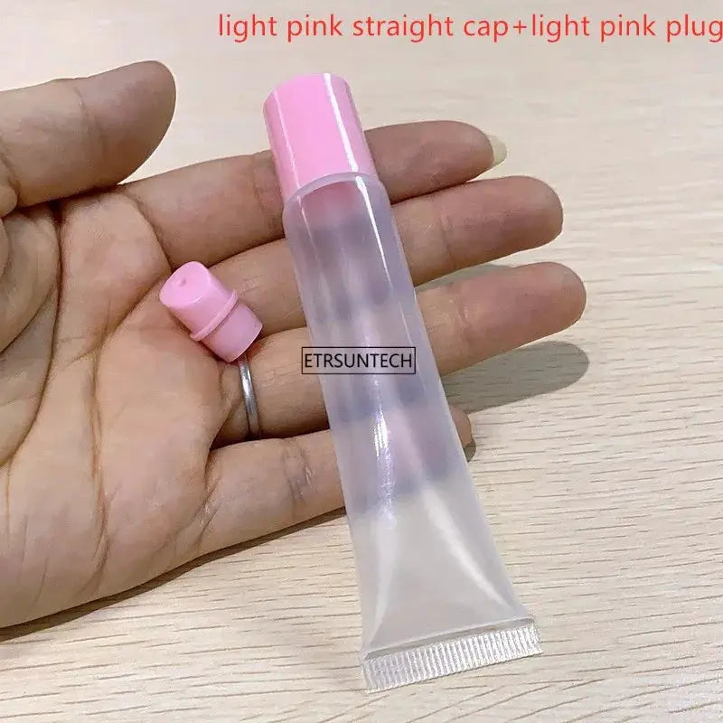 Clear lip gloss container with light pink cap and pink plug; 2 pieces shown