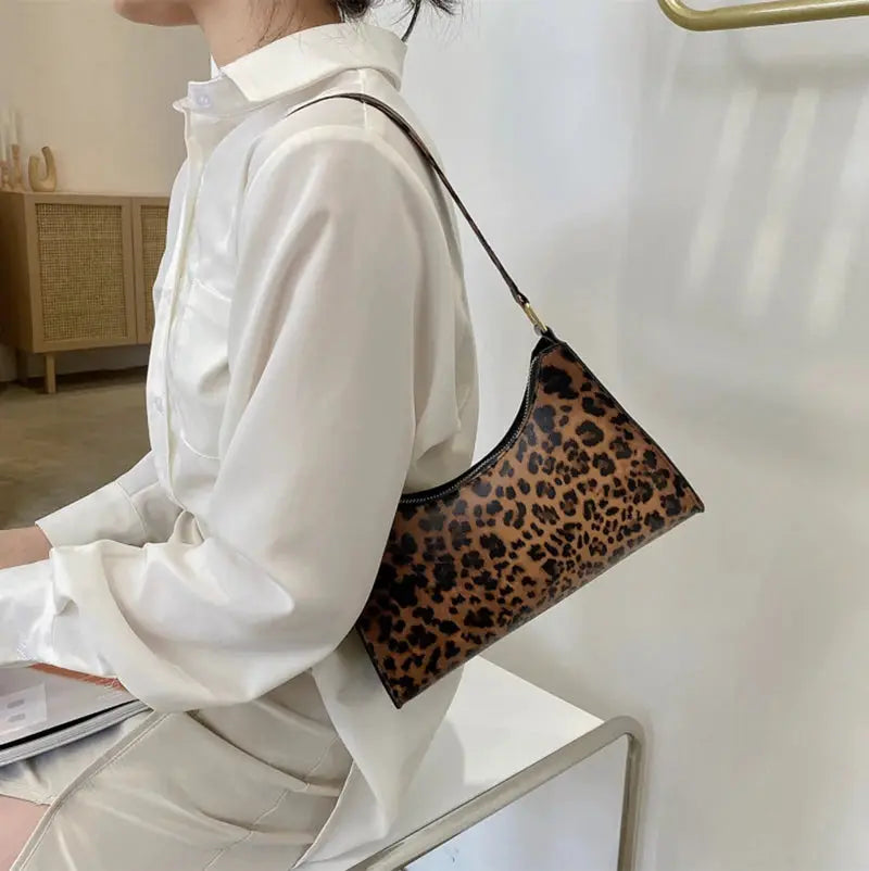 Simples Market leopard print PU leather shoulder bag worn over a white blouse.
