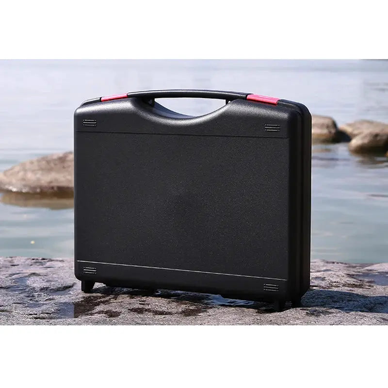 Portable black plastic tool box with handle, outdoor storage case on rocky shore
