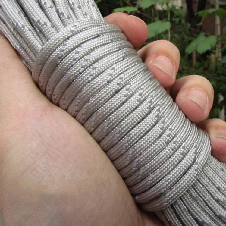 Reflective paracord rope, 7-strand 4mm 550, gray-silver, held in a hand