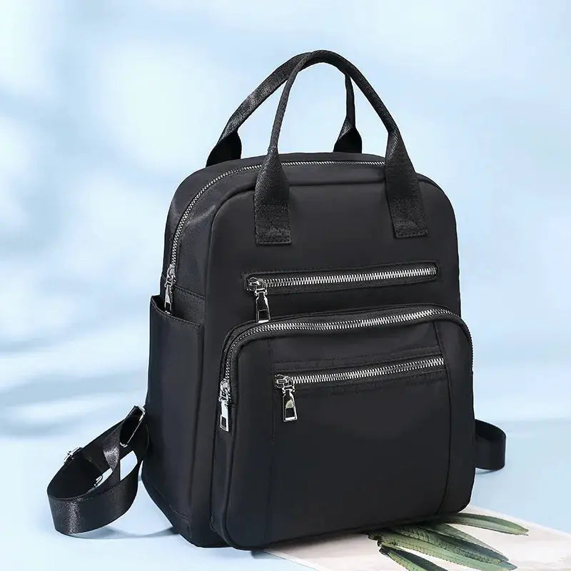Black waterproof Oxford backpack with multiple zip pockets, dual top handles and adjustable straps