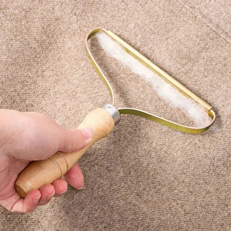 Portable lint remover by Simples Market with wooden handle and brass oval head for pet hair on clothing and carpet