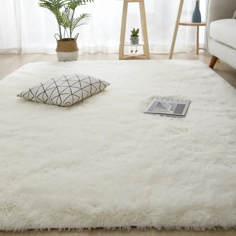 Large white fluffy living room rug with a geometric-pattern pillow and magazine.