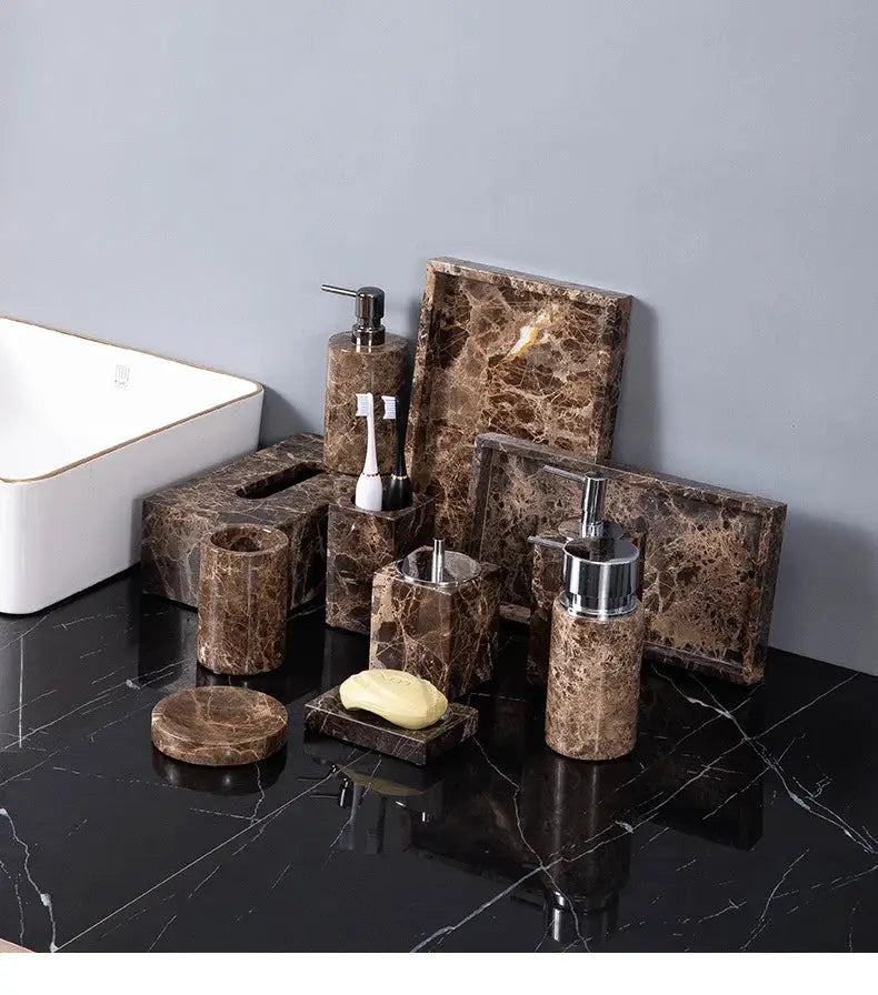 Emperador Dark brown marble bathroom set with toothbrush holder, soap dish, and soap dispenser on a black marble counter.