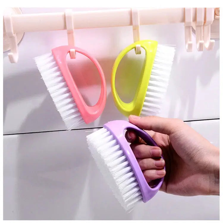 Egg-shaped cleaning brushes, three colorful handheld tools with soft white bristles in pink, yellow, and purple.