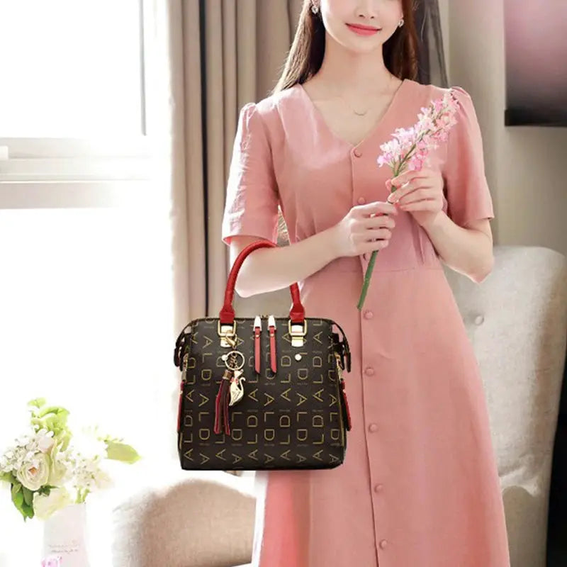 Women PU leather handbag with English letter print, red top handles, tassel accents, large-capacity tote